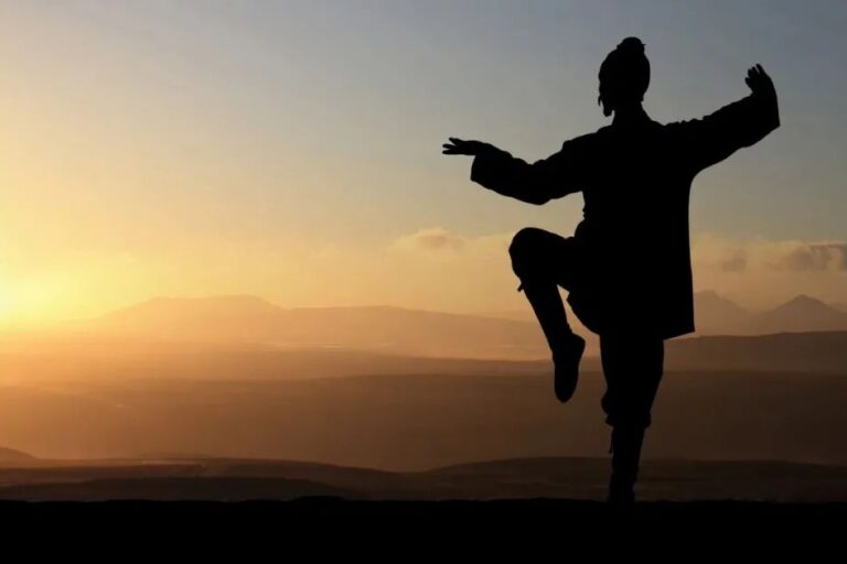 monk sunset Chinese Taoist monk engaged in the practice of Qigong atop a tranquil mountain during sunset. The monk is standing in a classic martial arts pose, demonstrating the harmonious balance of energies - Jing, Qi, and Shen. His serene stance against the backdrop of the setting sun beautifully symbolizes the cultivation and refinement of energy within the Taoist practices of Neigong and Neidan, leading to improved health, unlocking of extrasensory abilities, and the path to enlightenment.